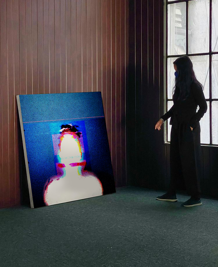 Um quadro encostado na parede com a sihueta de uma mulher em branco e fundo azul. Uma mulher de preto olha a pintura. a sala tem paredes de madeira e uma janela