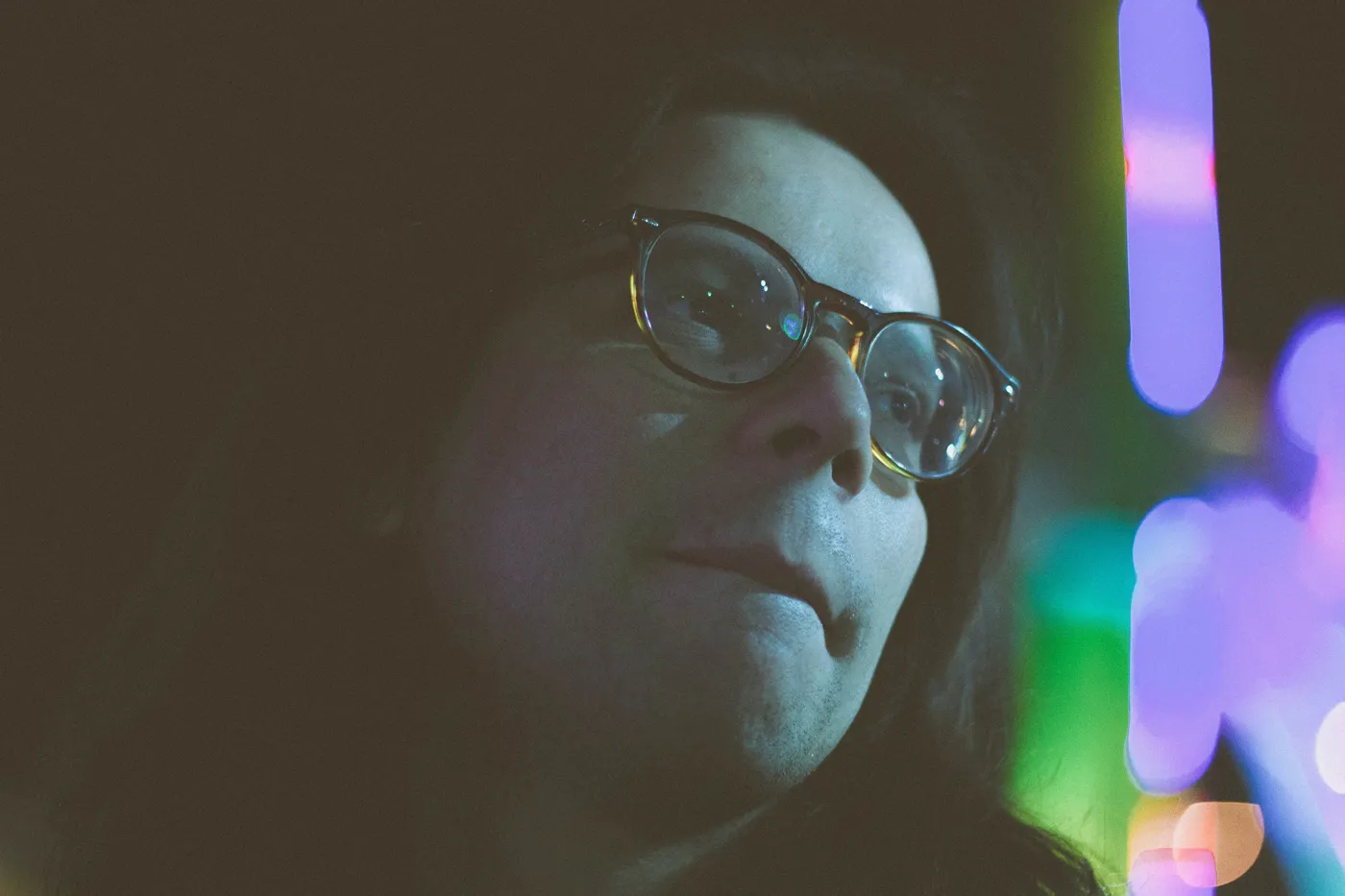 Night Portrait in Neon Light – Close-Up Street Photography by Rodrigo Baumgratz
This close-up portrait by Rodrigo Baumgratz captures a contemplative moment in the midst of vibrant night lights. Shot in a likely public space or event, the subject’s pensive expression and the reflections on their glasses contrast with the colorful blur of neon in the background. Ideal for portfolios focused on urban portraiture, night photography, or introspective visual storytelling, this image balances intimacy with a sense of ambient chaos.  