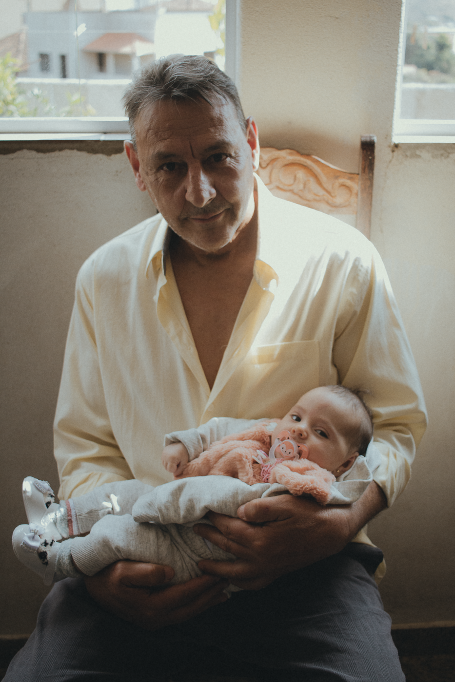 Intimate Generational Portrait – Father and Baby in Natural Light by Rodrigo Baumgratz
In this emotive photograph by Rodrigo Baumgratz, a father holds his child with quiet dignity and affection. The natural light gently illuminating the scene enhances the emotional resonance of this generational encounter. Perfect for documentary family photography, this portrait reflects themes of ancestry, tenderness, and human connection across time. Ideal for portfolios focused on intimate storytelling and expressive portraiture.  