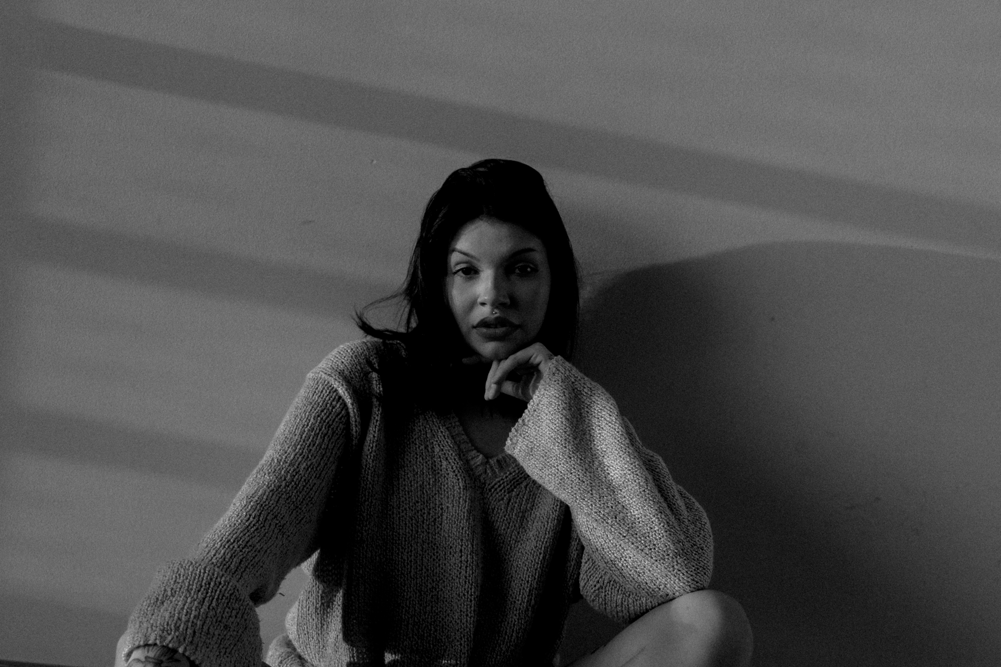 Minimalist Black and White Portrait with Natural Light – Rodrigo Baumgratz Photography
This minimalist black and white portrait by Rodrigo Baumgratz captures a woman seated in soft, directional light, her gaze calm yet assertive. The shadows cast on the wall behind her add structure and rhythm to the composition, emphasizing both intimacy and clarity. Ideal for portfolios focused on expressive portraiture, monochrome storytelling, or indoor natural light work, the image balances human presence with aesthetic restraint.