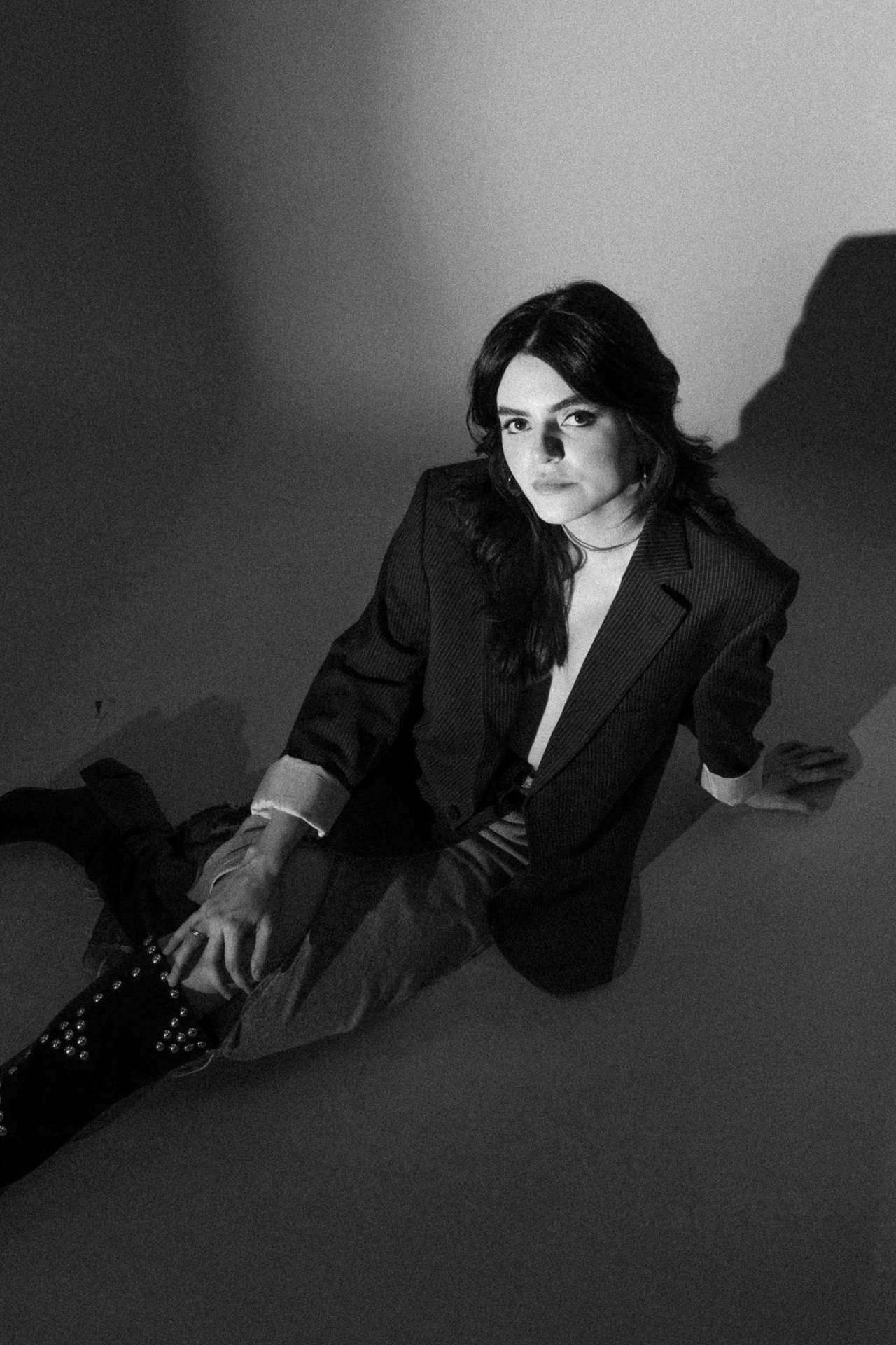 Black and white photo of a woman. Up angle, she is looking at the camera