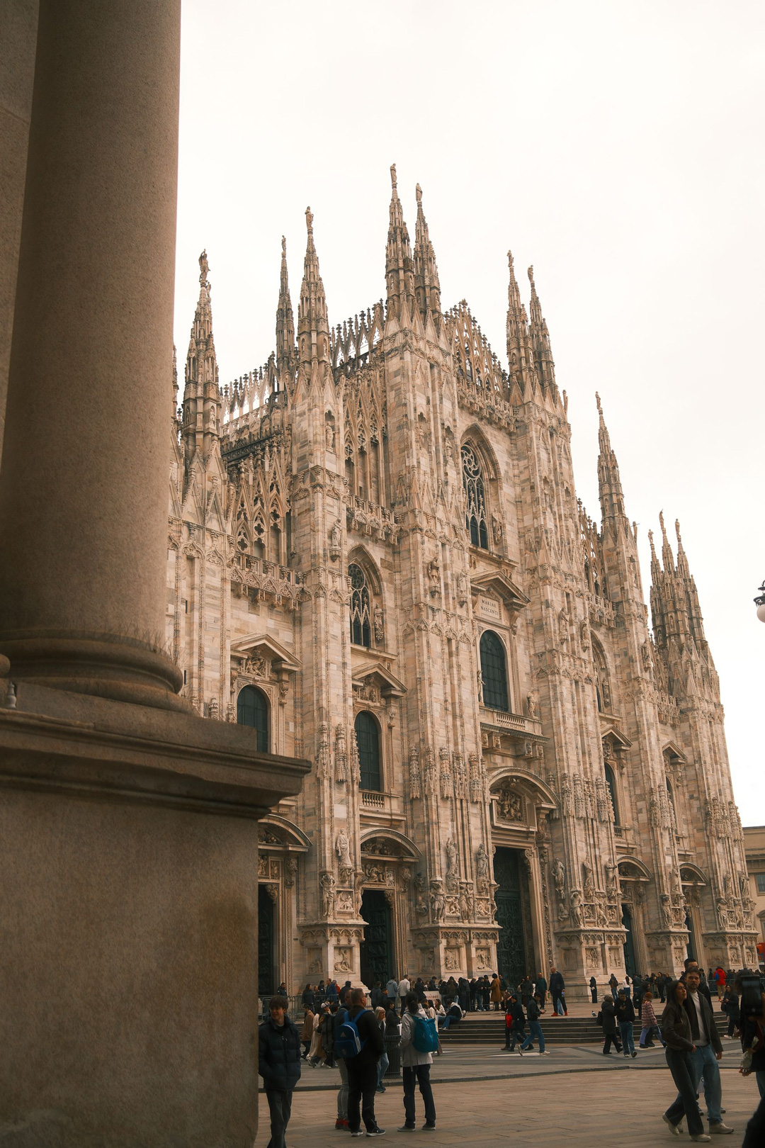 Duomo di Milano through the Artist’s Eye by Rodrigo Baumgratz This evocative architectural photograph by Rodrigo Baumgratz frames the iconic Duomo di Milano, capturing its Gothic spires in dialogue with the urban movement below. The slight perspective shift, taken from behind a figure, transforms the cathedral from mere monument into a living stage of human presence and transcendence. The image highlights Milan street photography, architectural detail, and artistic urban storytelling, making it ideal for portfolios that explore the intersection between history, faith, and contemporary life.