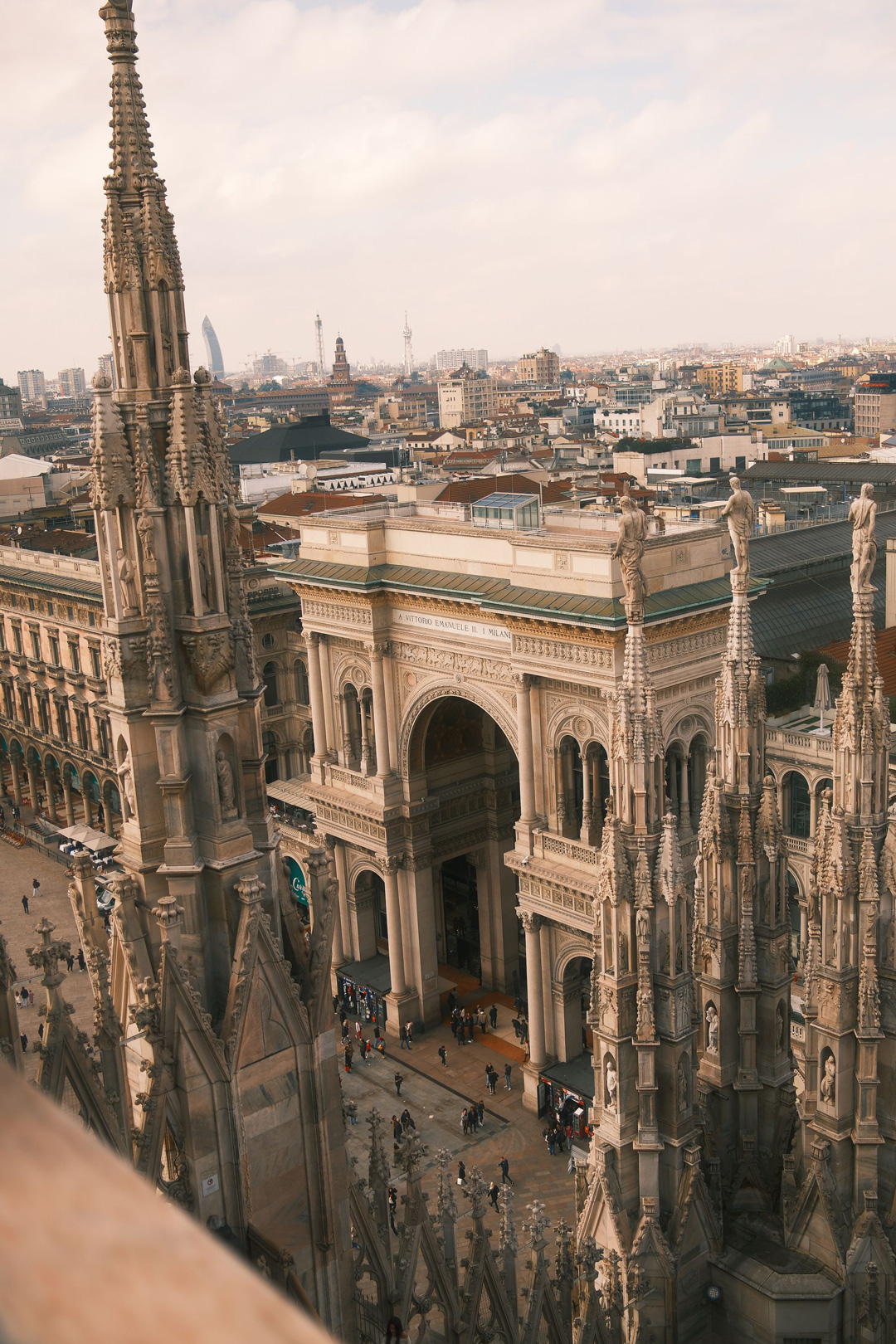 Architectural Panorama – Galleria Vittorio Emanuele II and Gothic Spires in Milan by Rodrigo Baumgratz From the rooftop of the Duomo di Milano, Rodrigo Baumgratz captures an architectural dialogue between Gothic spires and the elegant arch of the Galleria Vittorio Emanuele II. The sharp stone pinnacles pierce the frame, while the Renaissance-style arcade opens into the city below. The photograph merges vertical drama and urban rhythm, reflecting Milan as both sacred and metropolitan. Perfect for portfolios highlighting architectural photography, European travel aesthetics, or the interplay of history and modernity in Italian cities.