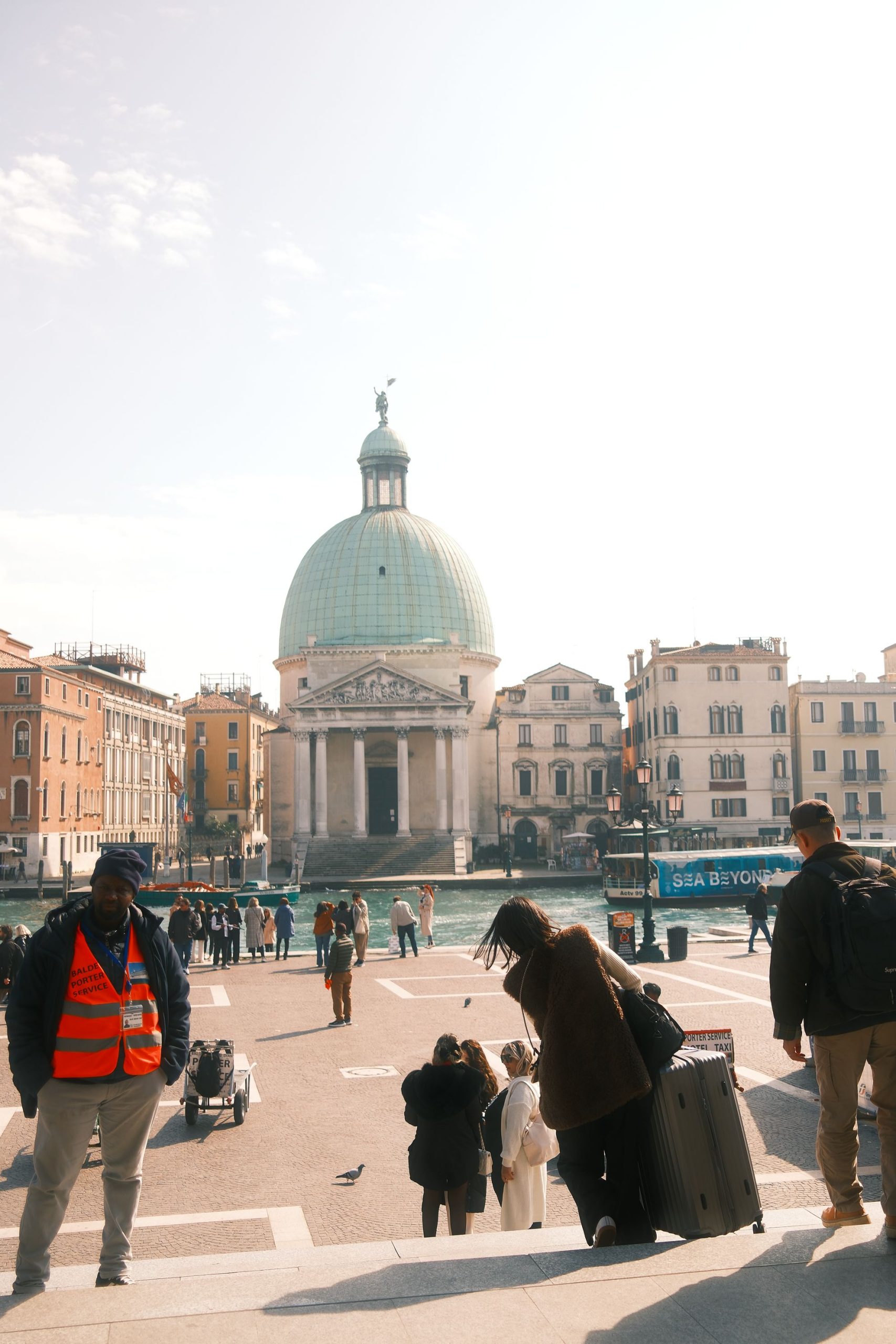 Urban Life and Classical Architecture in Venice – Travel Photography by Rodrigo Baumgratz Set in front of San Simeone Piccolo, this photograph captures the intersection of architecture and daily movement in Venice. Rodrigo Baumgratz uses balanced composition and natural light to frame the contrast between the timeless solidity of neoclassical form and the fluid presence of travelers, evoking themes of transience, orientation, and arrival—ideal for editorial, travel branding, or cultural storytelling.