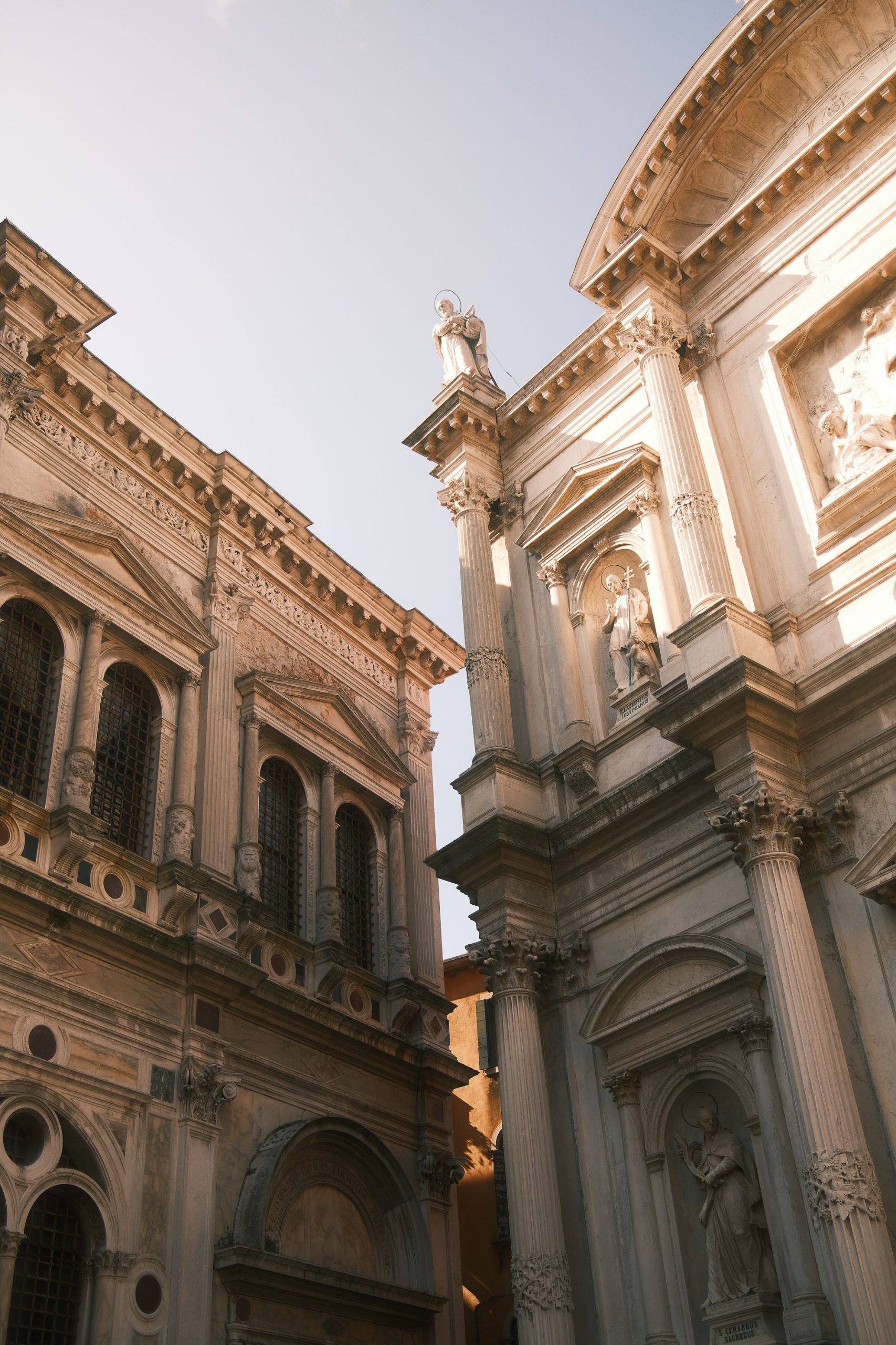 Renaissance Facades in Venetian Light – Architectural Photography by Rodrigo Baumgratz This image captures the meeting of two Renaissance-style façades in Venice, where classical symmetry and sculptural detail are enhanced by the soft glow of late afternoon light. Rodrigo Baumgratz uses architectural framing and tonal restraint to reveal texture, rhythm, and historical weight—ideal for editorial, curatorial, or commercial projects seeking refined architectural imagery rooted in atmosphere.