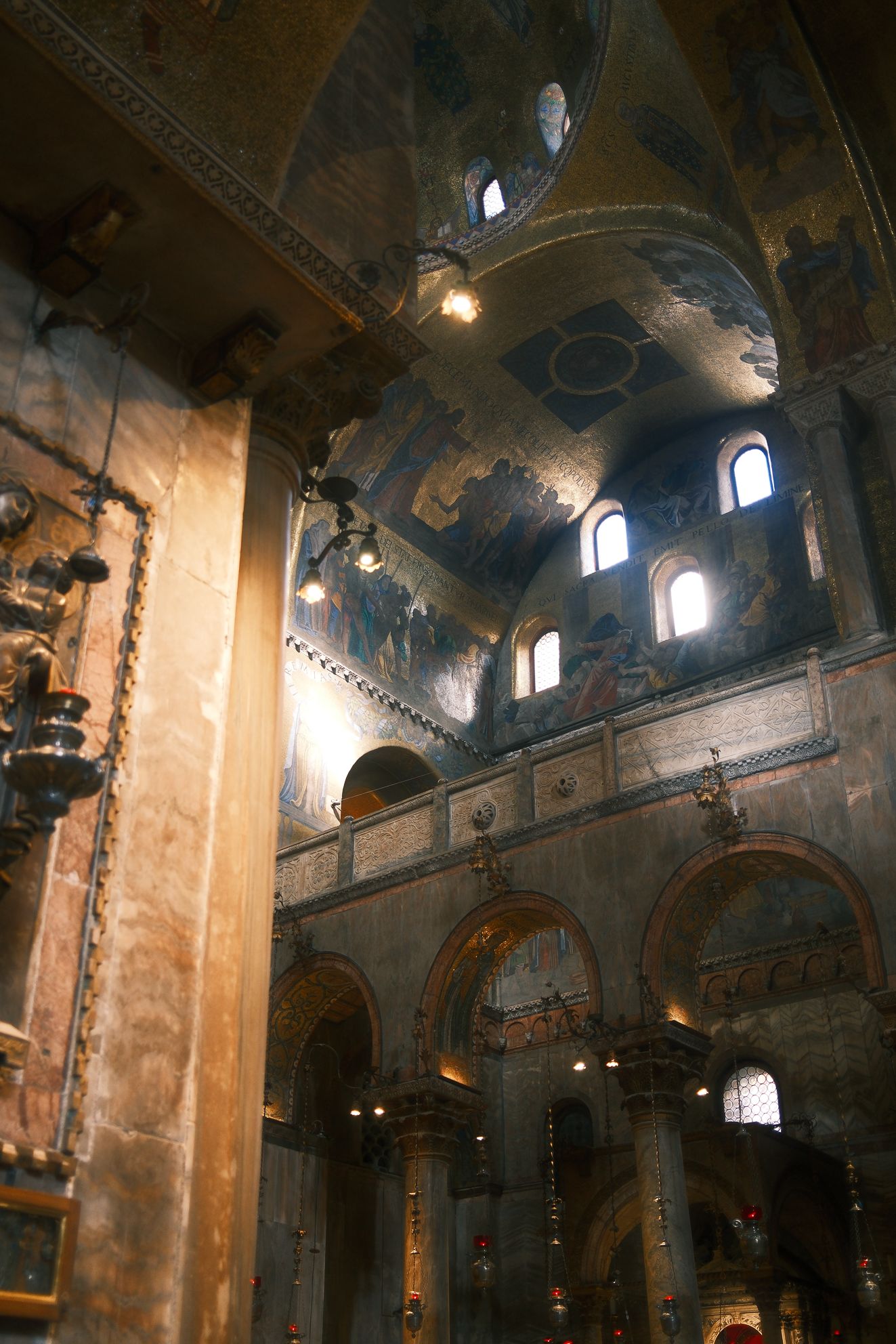 Venice Basilica Interior – Golden Mosaics & Light Play by Rodrigo Baumgratz This evocative photograph by Rodrigo Baumgratz captures the intricate Byzantine mosaics and arches inside Venice’s Basilica di San Marco. Golden light spills through narrow windows, illuminating centuries-old frescoes with a timeless glow. The composition highlights the interplay of sacred art and raw texture, blending refinement with a sense of chaos. Ideal for portfolios focused on architectural photography, sacred spaces, or artistic travel imagery, this work embodies a visceral yet contemplative perspective on Venetian heritage.